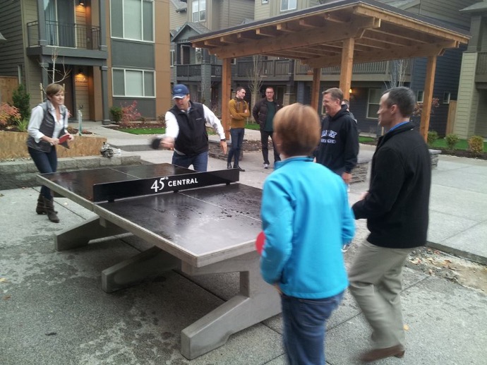 Adults playing ping pong on concrete ping pong table Parents play too on concrete Games