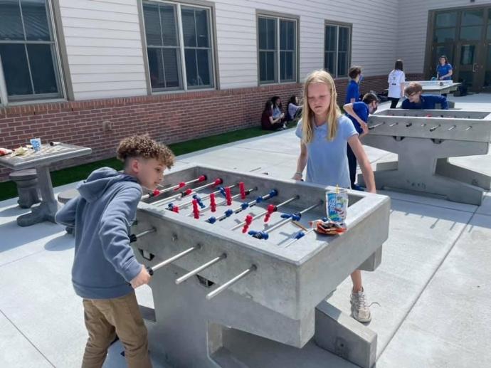Students play on concrete foosball table in Doha Qatar