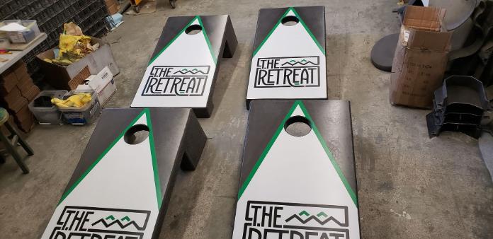 The Retreat Concrete cornhole boards with graphis
