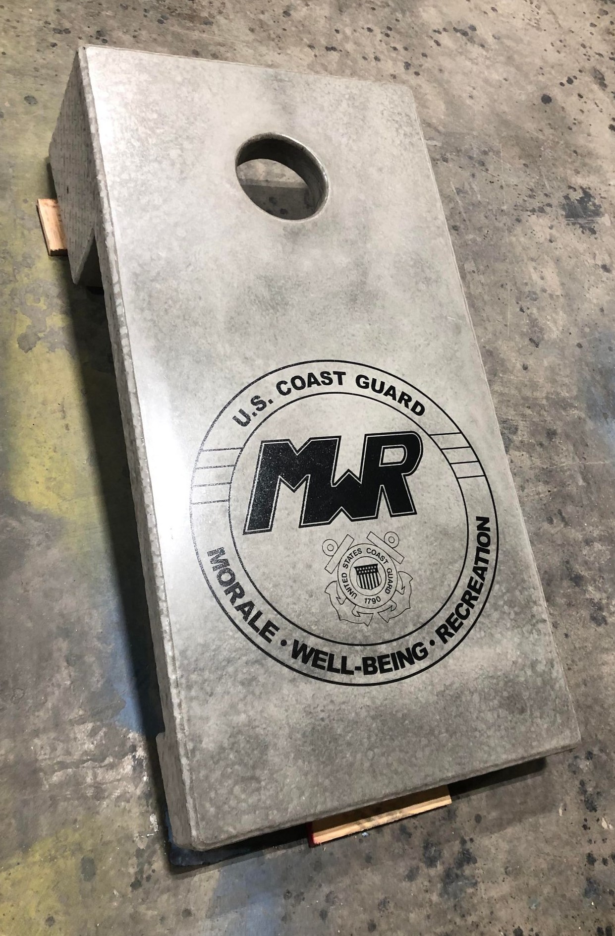 Permanent concrete cornhole boards with Stone Age logo at outdoor community venue
